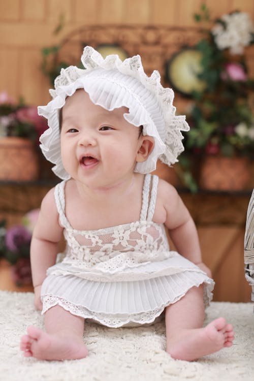 無料 白い頭飾りと白いドレスの赤ちゃん 写真素材