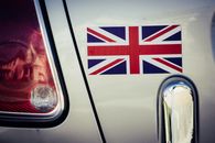 Union Jack sticker on car back with taillight detail in urban setting.