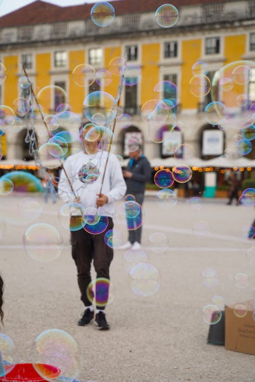 A Man Blowing Bubbles at a Festival