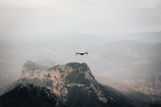 Aerial view of a drone flying over foggy mountains in a serene landscape.