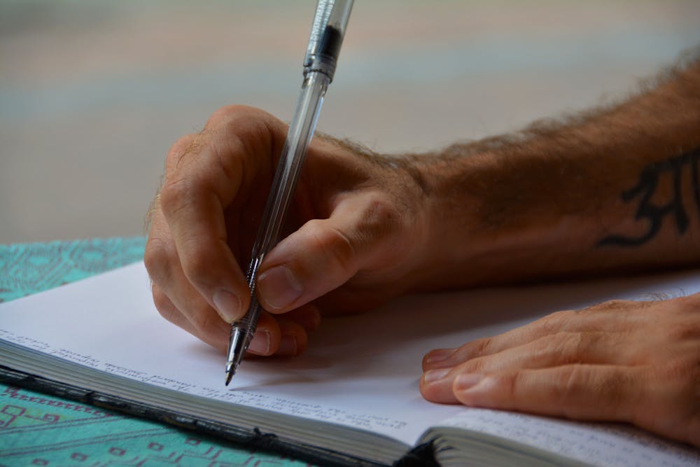 Man writing a letter. | Photo: Pexels