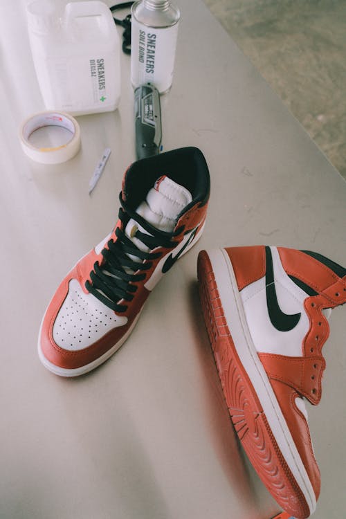 White and Orange Nike Air Jordan 1 with a Black Swoosh and Shoelaces 