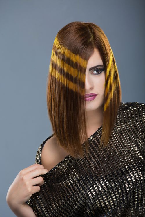 Free Portrait of a woman showcasing a unique hairstyle and bold makeup. Stock Photo