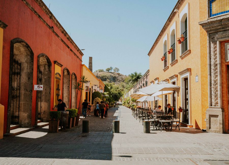 Colorful street scene in Tequila, Jalisco, showcasing vibrant buildings under a clear sky.