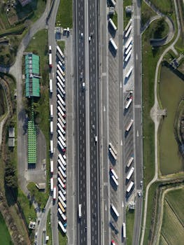 Highway traffic captured from above showcasing trucks and parked vehicles in Roncade, Italy.
