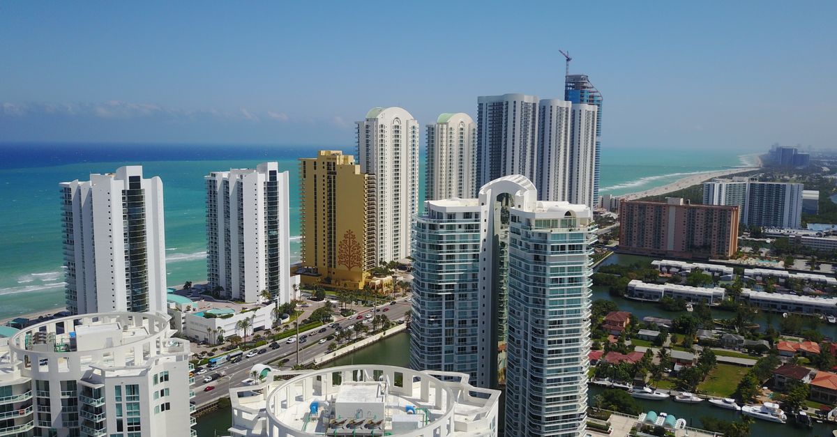 Aerial view of modern Sunny Isles Beach skyline with ocean in background.