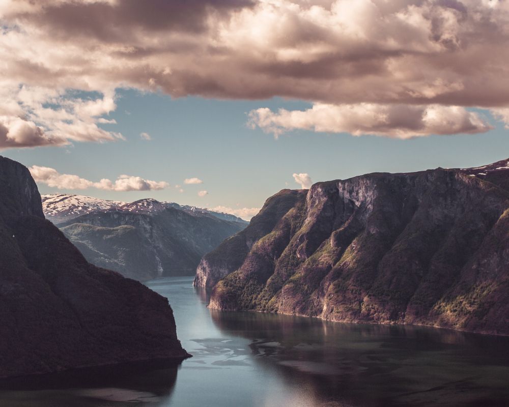Aurlandsfjord la apus, în Flåm, cu munți și cer senin