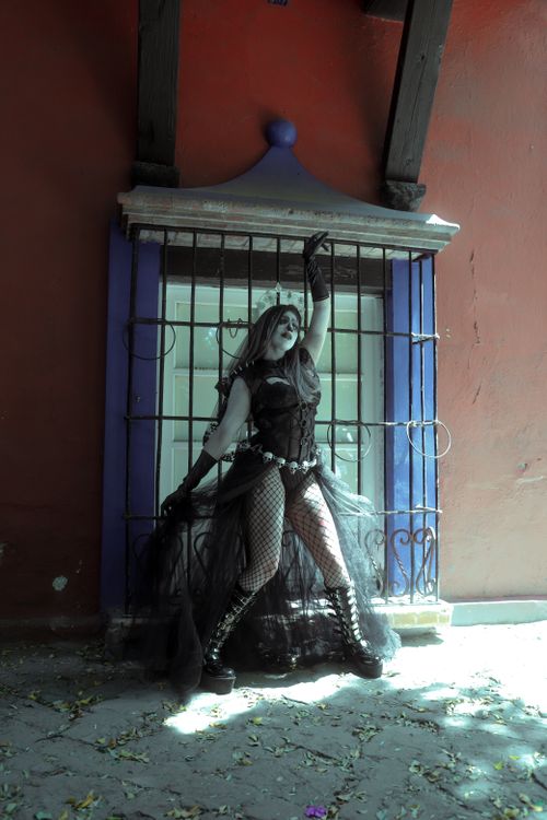 Free Woman in gothic Halloween costume posing outdoors by a window in Mexico City. Stock Photo