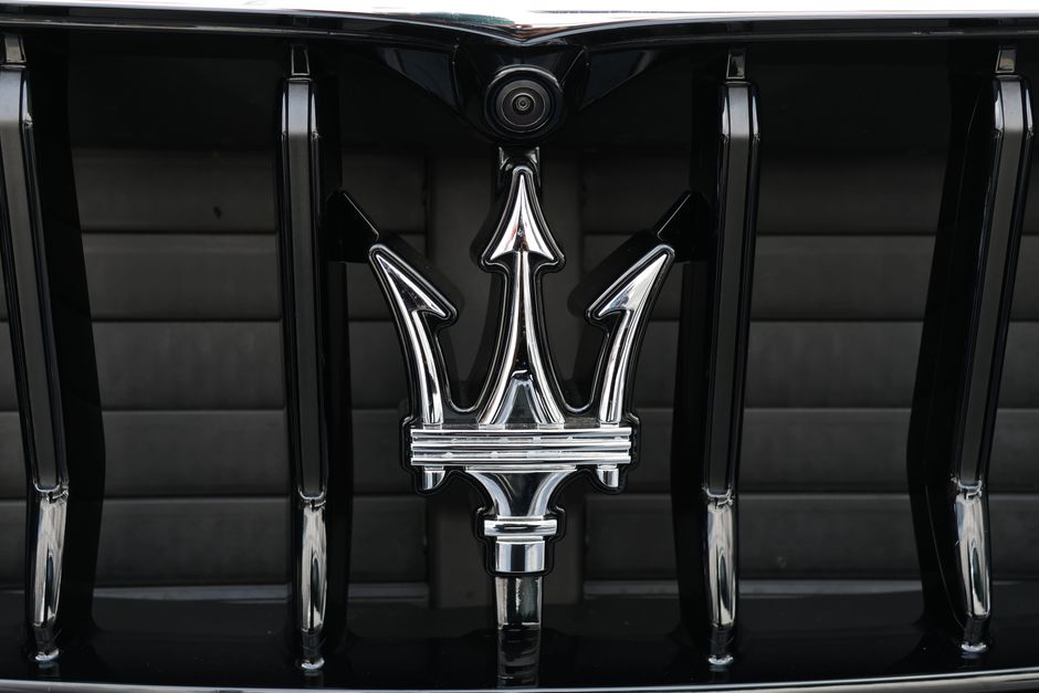 Close-up of Maserati car grill featuring the iconic trident emblem showcasing luxury and elegance.
