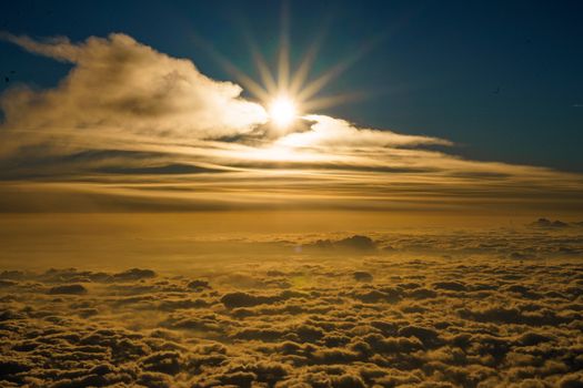A stunning view of golden sunlight piercing through clouds at sunrise, creating a beautiful skyscape.