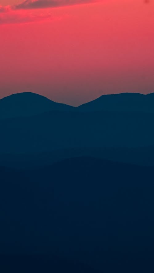Silhouetted Mountains under a Dramatic, Pink Sunset Sky 