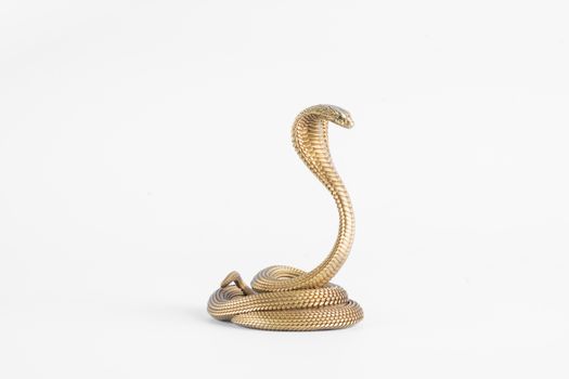 Elegant golden cobra phone stand handcrafted with intricate patterns on a white background.