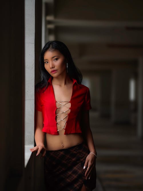 Young Woman in a Red Shirt and Plaid Skirt 