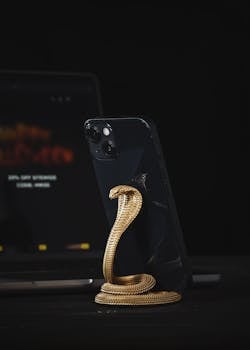 Elegant golden cobra phone stand holding a smartphone, with a sleek design for modern environments.