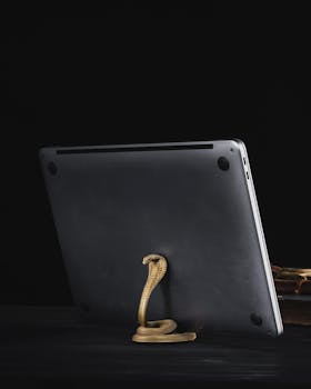 A golden cobra-shaped metal stand elegantly supports a tablet, adding a touch of luxury and style.