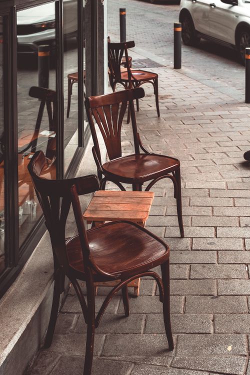 Free Wooden chairs outside a café on a sidewalk in İstanbul, Türkiye, exuding a rustic urban charm. Stock Photo