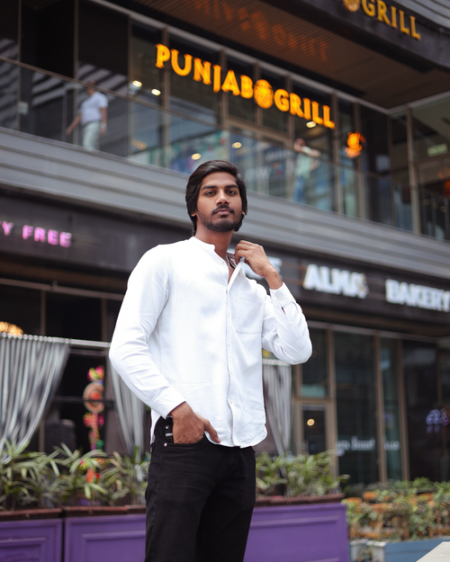 Free Stylish young man stands confidently outside Punjab Grill restaurant, expressing modern fashion. Stock Photo