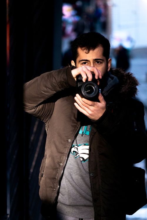 Free A young man capturing an outdoor photo in an urban environment at night. Stock Photo