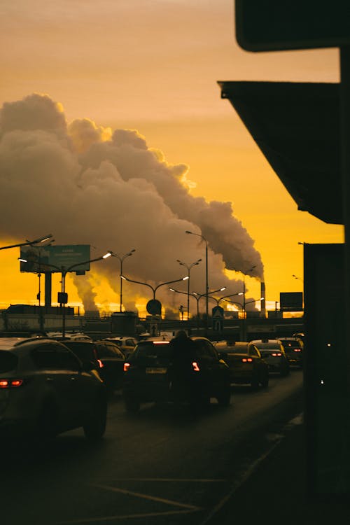 Industry Smoke over Cars in Traffic Jam at Sunset