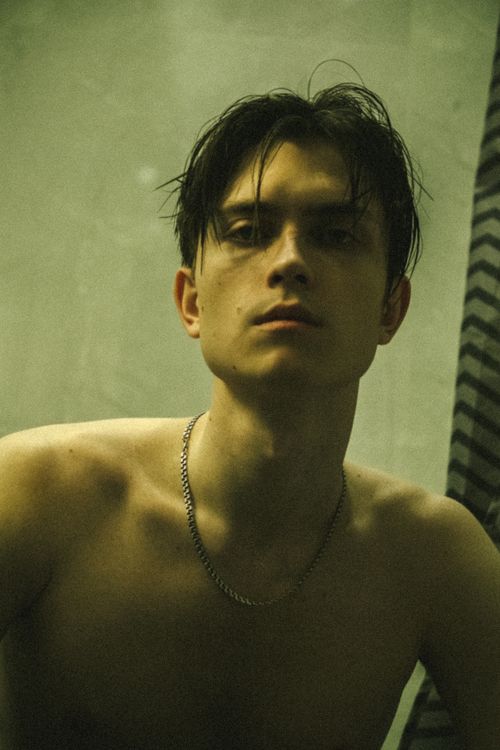 Free Artistic portrait of a topless young man wearing a necklace, exuding a contemplative mood. Stock Photo