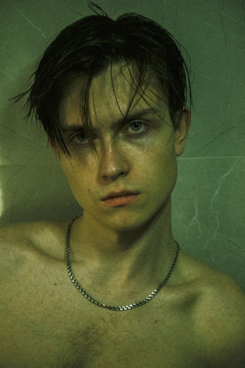 Free Moody portrait of a young man with a chain necklace, showcasing a vintage and artistic aesthetic. Stock Photo