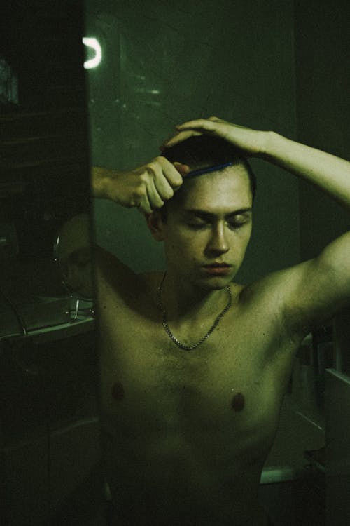 Portrait of Topless Man Combing Hair