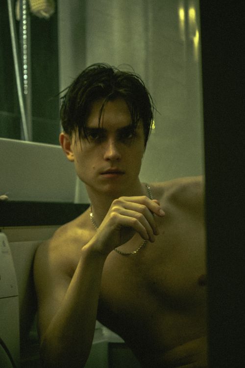 Free A moody portrait of a shirtless young man posing indoors with dramatic lighting. Stock Photo