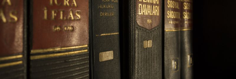 Detailed close-up of law and regulation books on a bookshelf, emphasizing education and knowledge.