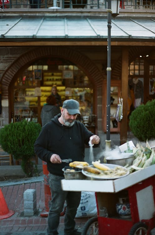 Street Food Vendor Salting Corn · Free Stock Photo Street Food Vendor Salting Corn · Free Stock Photo
