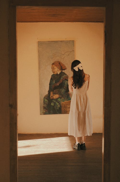 Woman in White Dress Watching Painting on Wall