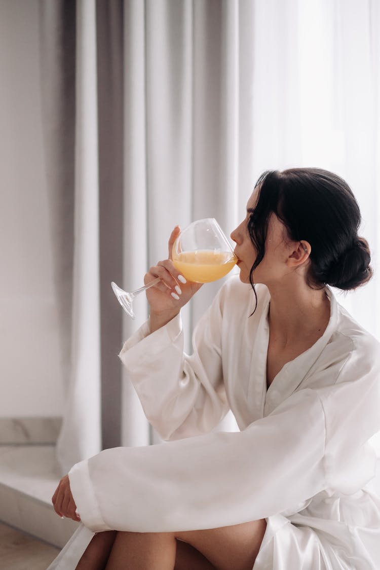 Woman In Robe Drinking Juice