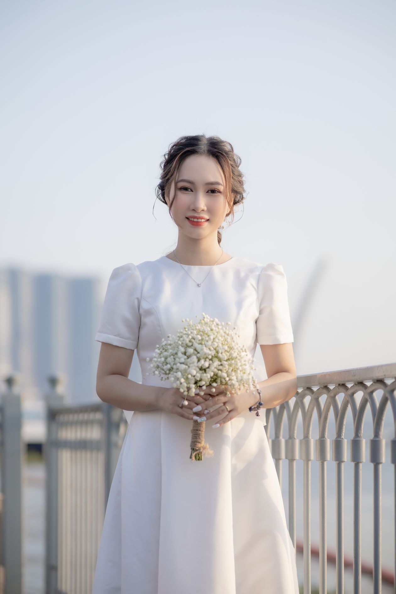 Bride-to-be in a white dress holding a bouquet of baby's breath