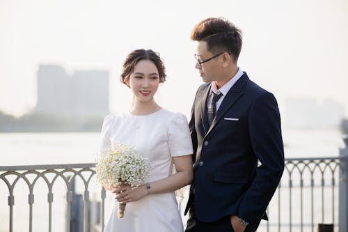 Newlyweds Standing Together on a Bridge