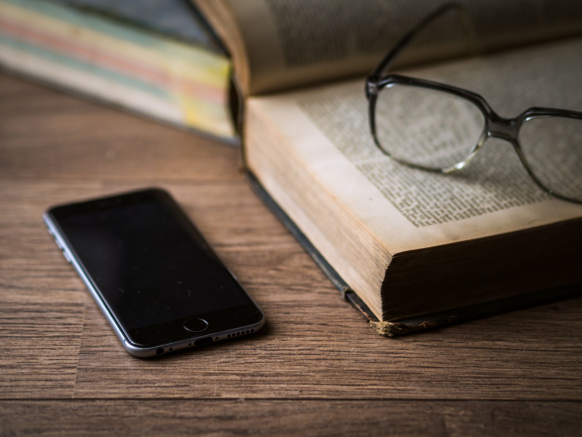 Close-up of a smartphone with its screen on, on a plain desk