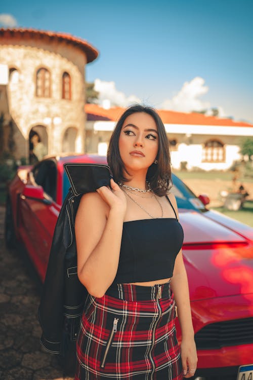 A Young Woman in front of a Red Car