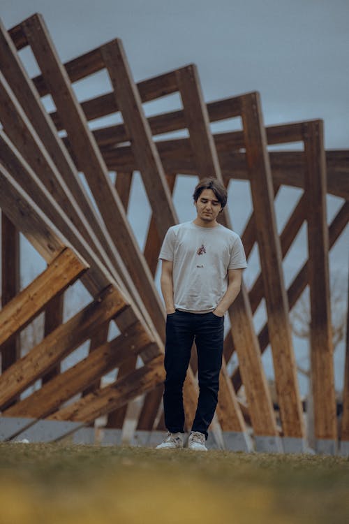 Man Standing in front of a Wooden Construction 