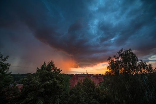 Dramatic clouds at sunset over Szczecin rooftops, capturing the evening ambiance and skyline.