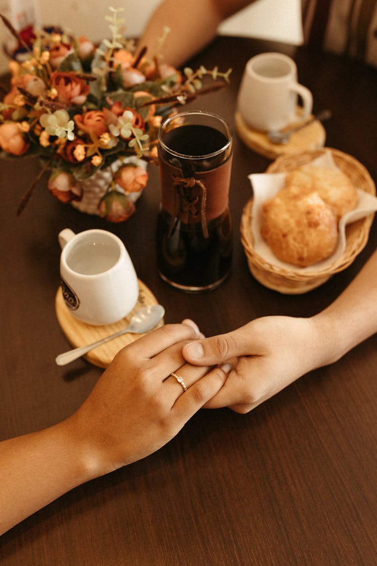 Couple Holding Hands On The Table 