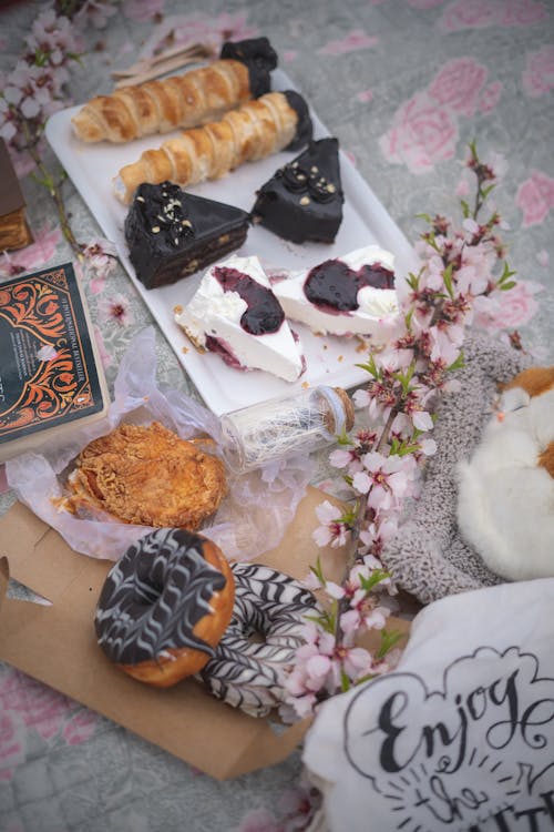 Assorted Pastries and a Twig with Blooming Flowers Lying on a Table