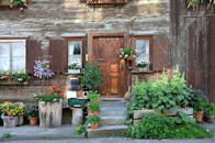 迷人的乡村房屋入口装点着木制门和色彩缤纷的花盆，营造出充满活力的场景