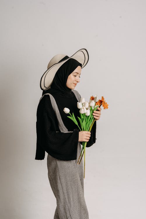 A woman in a hijab holding flowers