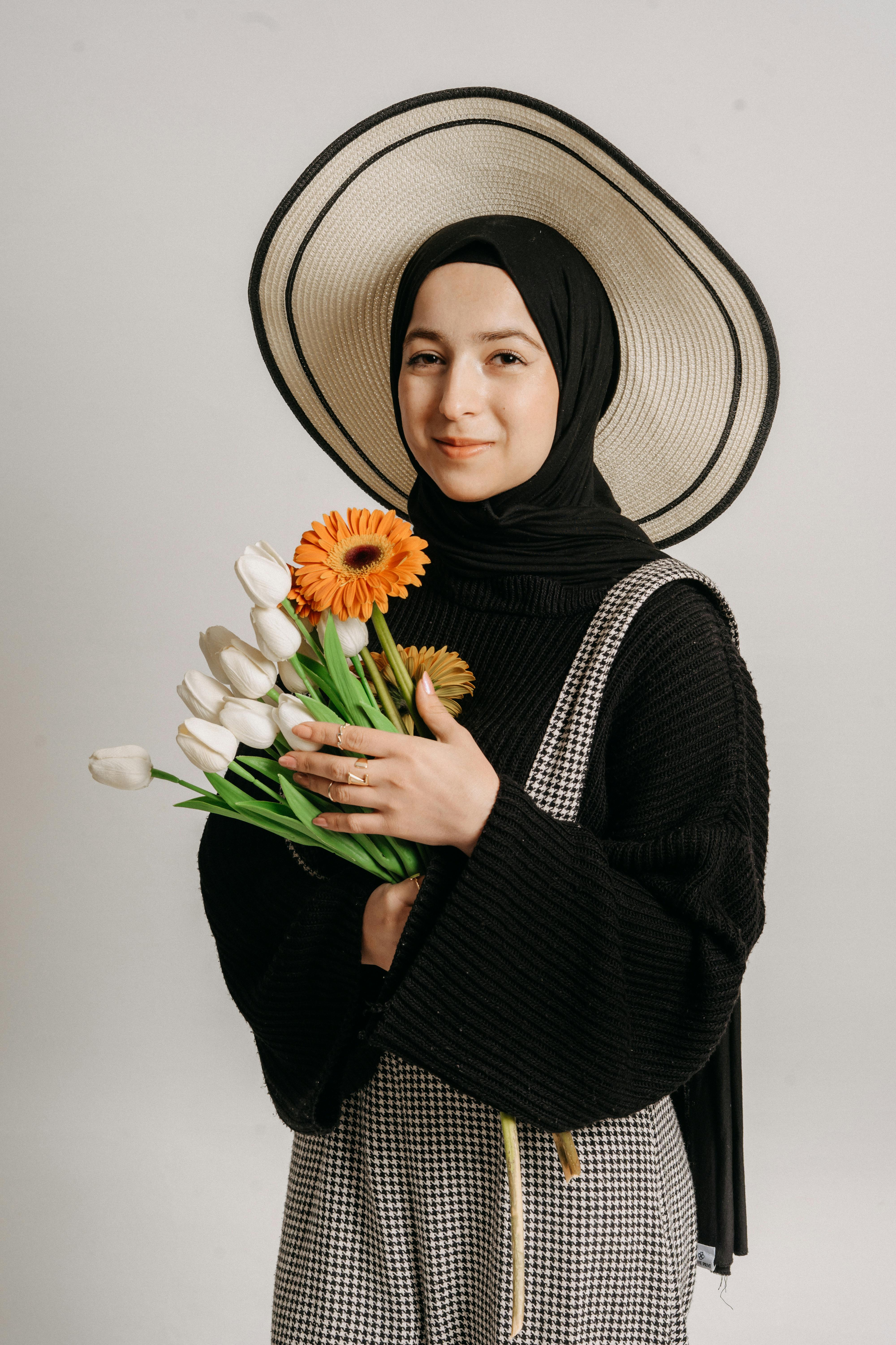 a woman in a hijab holding flowers