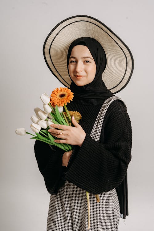 A woman in a hijab holding flowers