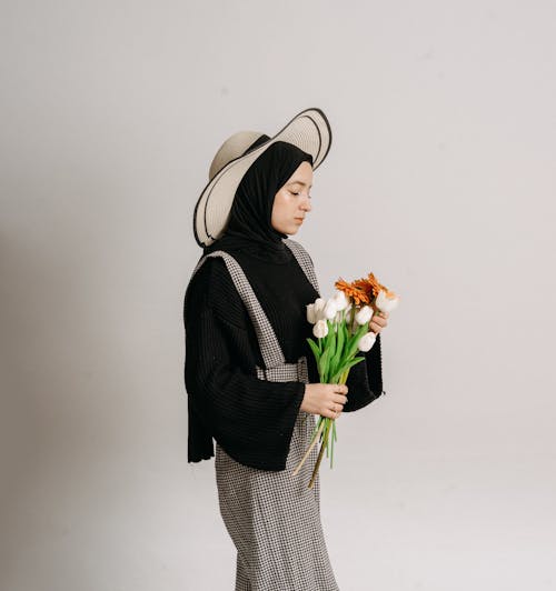 A woman in a hijab holding flowers