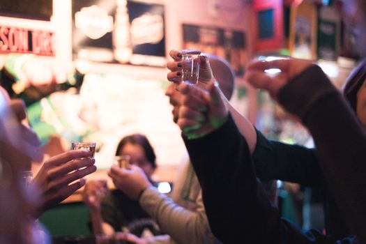 Group of friends enjoying a lively night out with drinks at a bar.