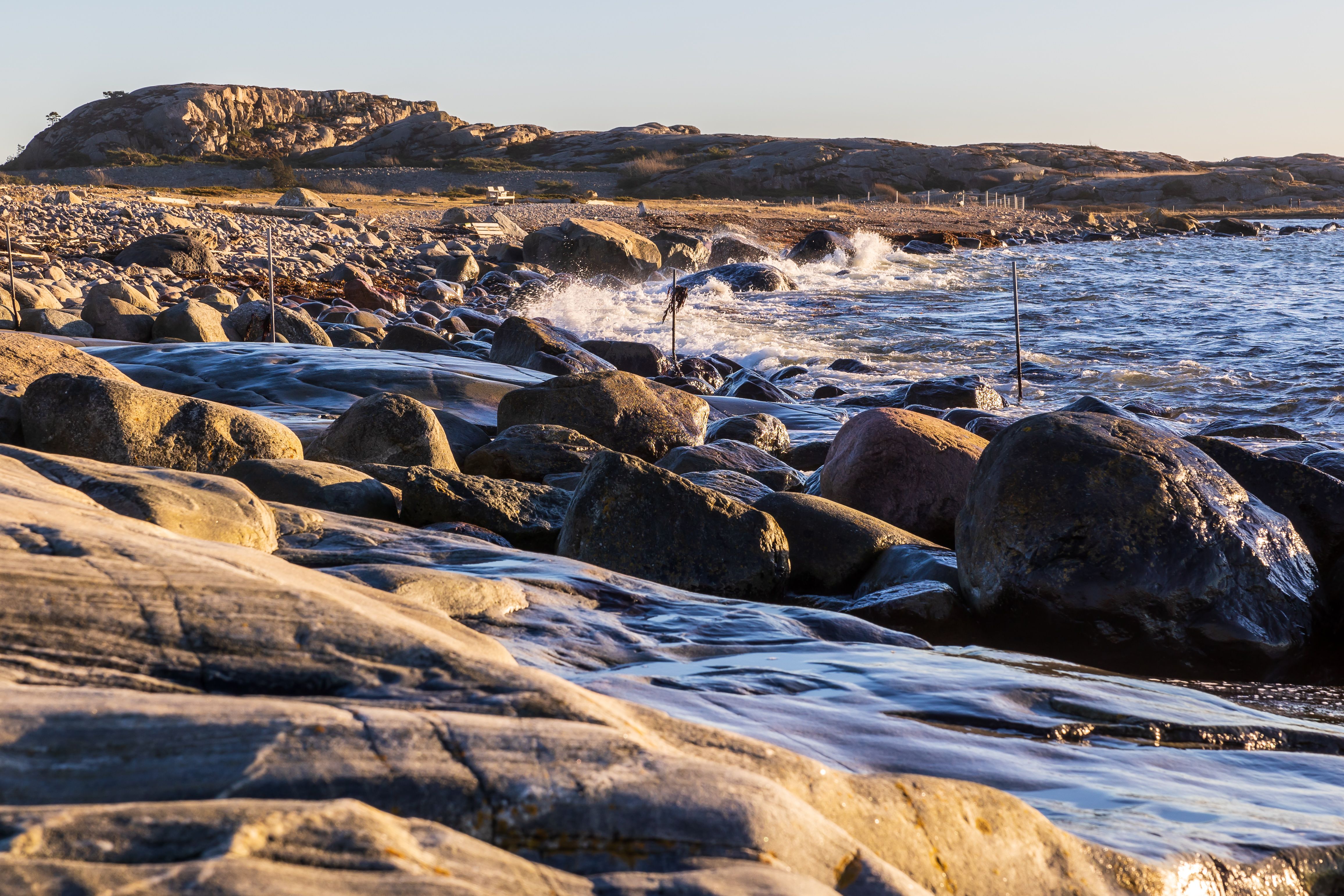 Dramatic rocky coast of Havstenssund, Sweden, with waves crashing during sunset.