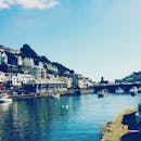 在英国晴朗的天空下，卢港风景如画，船只和房屋点缀其间