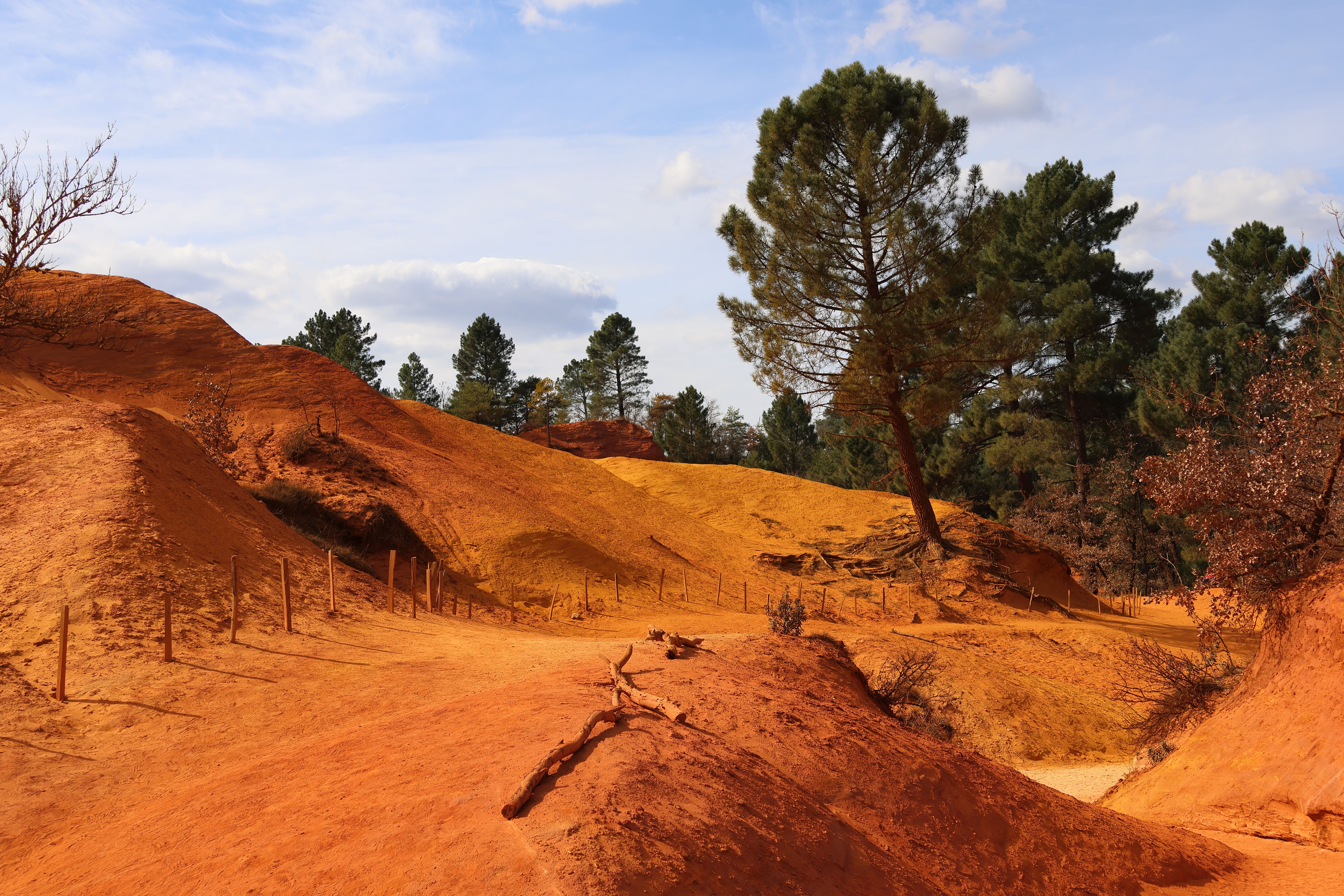 Explore the vibrant orange ochre hills and scenic trails in the captivating landscape of Rustrel, France. Explore the vibrant orange ochre hills and scenic trails in the captivating landscape of Rustrel, France.