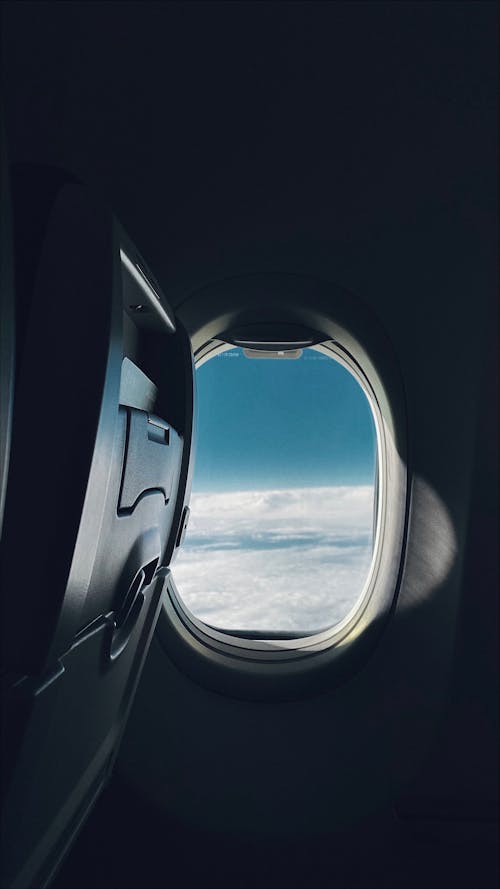 View of Blue Sky and White Clouds from an Airplane Window 