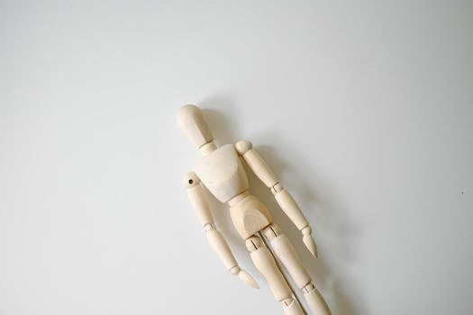 A wooden artist mannequin on a white background, showcasing minimalism and creativity.